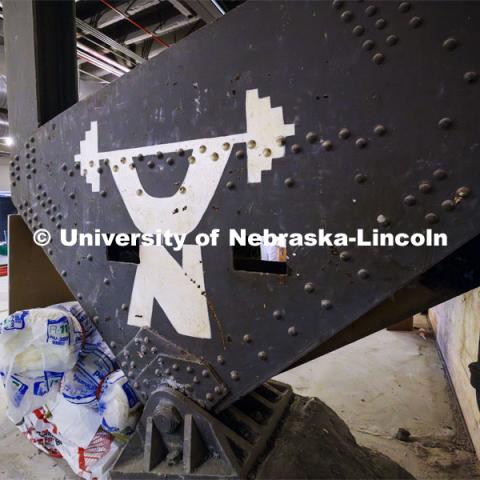 When the women’s locker room was gutted, it revealed the original ironwork for the Coliseum. Stenciled to a girder was a stylized Nebraska weightlifter from when the area was a weight room. Construction continues to renovate the locker rooms and a new weight training and conditioning area in the Campus Rec. Campus Recreation Center. July 30, 2024. Photo by Craig Chandler / University Communication and Marketing.