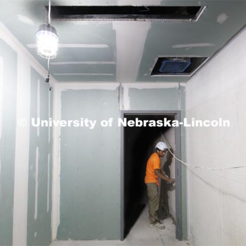 Ben Mejia of JSW Contractors works on the drywall in the new area. Construction continues to renovate the locker rooms and a new weight training and conditioning area. Campus Recreation Center. July 30, 2024. Photo by Craig Chandler / University Communication and Marketing.