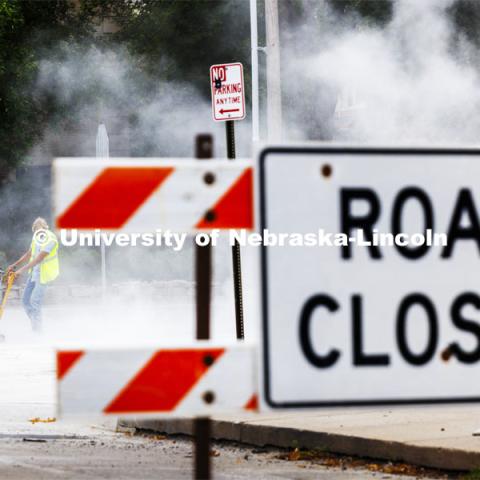 A construction worker runs a grinder as the intersection of 16th and S is completed. City Campus. August 16, 2024. Photo by Craig Chandler / University Communication and Marketing.