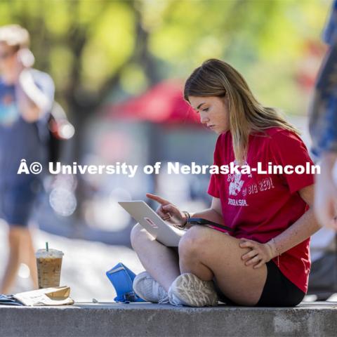 Ellie Shepperd, a freshman from Hay Center, Nebraska, studies on the Nebraska Union plaza. Students on city campus. September 3, 2024. Photo by Craig Chandler / University Communication and Marketing.