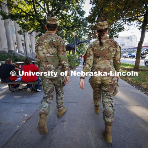 Air Force ROTC cadets Mason Beck, left, and Elena Burgwald walk toward Memorial Stadium an hour and a half before game time to prepare for the flyover. Nebraska vs. Illinois football game. September 20, 2024. Photo by Craig Chandler / University Communication and Marketing.