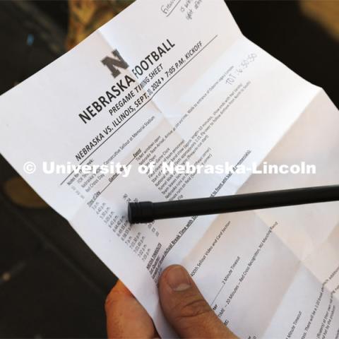 Air Force ROTC cadet Elena Burgwald goes over the pregame timing sheet which maps out to the second the precise order of events. Nebraska vs. Illinois football game. September 20, 2024. Photo by Craig Chandler / University Communication and Marketing.