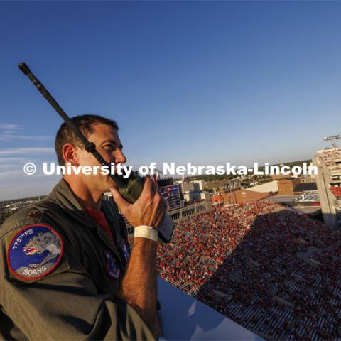 From atop the west stadium roof, Air National Guard Major Bobby Sullivan with the 175th fighter squadron of the 114th fighter wing based out of Sioux Falls, South Dakota, right, talks with Air Force ROTC cadets Mason Beck, left, and Elena Burgwald as they discuss the flyover and air force flying before the game. Nebraska vs. Illinois football game. September 20, 2024. Photo by Craig Chandler / University Communication and Marketing.