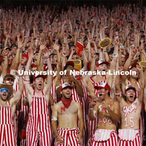 Cheering fans in the student section wear red and white striped overalls. Nebraska vs. Illinois football game. September 20, 2024. Photo by Craig Chandler / University Communication and Marketing.