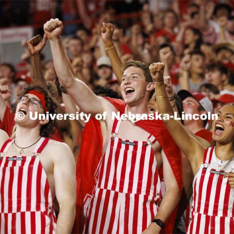 Cheering fans in the student section wear red and white striped overalls. Nebraska vs. Illinois football game. September 20, 2024. Photo by Craig Chandler / University Communication and Marketing.