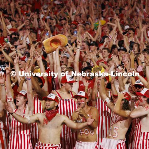 Cheering fans in the student section wear red and white striped overalls. Nebraska vs. Illinois football game. September 20, 2024. Photo by Craig Chandler / University Communication and Marketing.