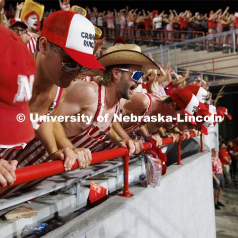 Cheering fans in the student section wear red and white striped overalls. Nebraska vs. Illinois football game. September 20, 2024. Photo by Craig Chandler / University Communication and Marketing.