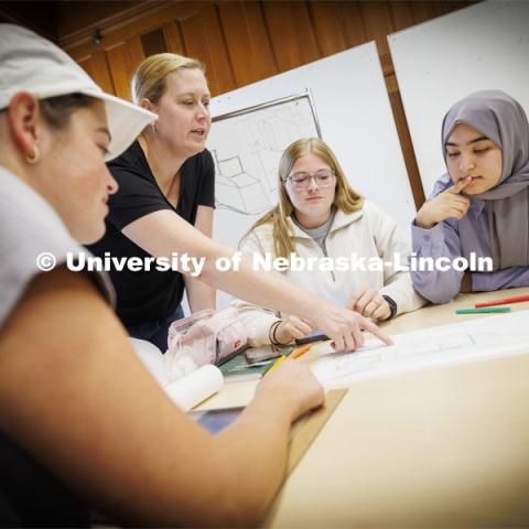 Students listen as Sonya Grace Turkman, Assistant Professor - Interior Design, critiques their project. DSGN 410 - Design Studio: Collaborate. Architecture photo shoot. September 25, 2024. Photo by Craig Chandler / University Communication and Marketing.