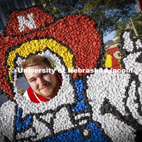 Husker cheer squad member Newt Johnson tries out the Herbie lawn decoration in front of the Phi Kappa Psi fraternity house. Cornchella Homecoming Parade and Cornstock. October 4, 2024. Photo by Craig Chandler / University Communication and Marketing.