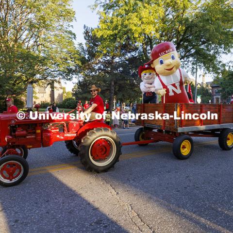 Husker cheer coach Jake Jundt pulls Herbie Husker and Lil’ Red using his family’s tractor and wagon. Cornchella Homecoming Parade and Cornstock. October 4, 2024. Photo by Craig Chandler / University Communication and Marketing.