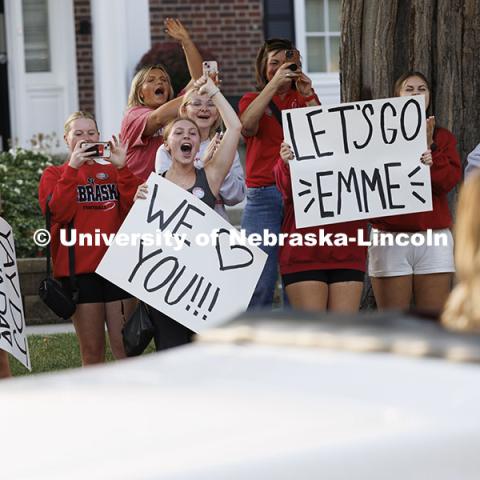 Grace Roberts, Kelli Kaufman and Madeline Petton hold signs to celebrate Homecoming Royalty Emmerson Putnam as she is driven past their Gamma Phi Beta sorority. Cornchella Homecoming Parade and Cornstock. October 4, 2024. Photo by Craig Chandler / University Communication and Marketing.