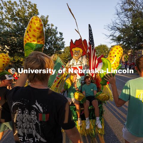 Phi Kappa Psi members bring the corn as they roll along in their decorated golf cart. Cornchella Homecoming Parade and Cornstock. October 4, 2024. Photo by Craig Chandler / University Communication and Marketing.