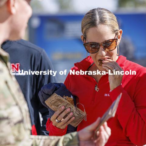 Emmeline Watson, Assistant Professor of Practice in the Durham School of Architectural Engineering and Construction, samples an apple cinnamon nutrition bar from a meal-read-to-eat. Faculty and staff were able to try many of the MRE options during the event. ROTC cadets on fall exercise. October 4, 2024. Photo by Craig Chandler / University Communication and Marketing.