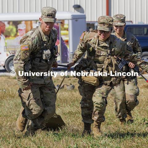 UNL cadet Max Holstrom, left, and Creighton cadet Mariska Suwanda pull a cadet on a sled to simulate helping and moving a wounded soldier. ROTC cadets on fall exercise. October 4, 2024. Photo by Craig Chandler / University Communication and Marketing.