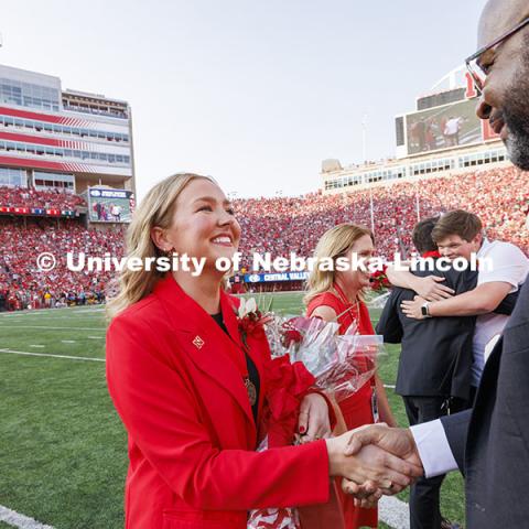 Homecoming royalty Emmerson Putnam, biological sciences major of Bellevue, Nebraska is congratulated by Chancellor Rodney D. Bennett. Nebraska vs Rutgers football game. Homecoming game. October 5, 2024. Photo by Craig Chandler / University Communication and Marketing.