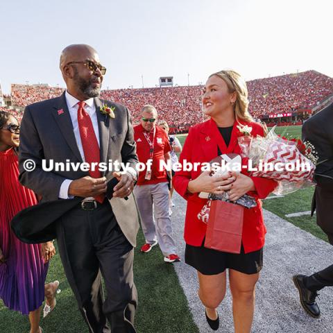 Chancellor Rodney D. Bennett, his wife, Temple (left) and homecoming royalty Emmerson Putnam, biological sciences major of Bellevue, Nebraska and Jaime Smith, a music education major of West Des Moines, Iowa, walk off the field following the halftime ceremony. Nebraska vs Rutgers football game. Homecoming game. October 5, 2024. Photo by Craig Chandler / University Communication and Marketing.