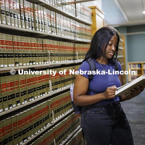 A law student studies in the stacks of the library. College of Law photoshoot. October 10, 2024. Photo by Craig Chandler / University Communication and Marketing.