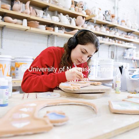 Senior Alex Napolitano works on glazing her gecko serving platter for a ceramics course inside Richards Hall. October 28, 2024. Photo by Jordan Opp / University Communication and Marketing.