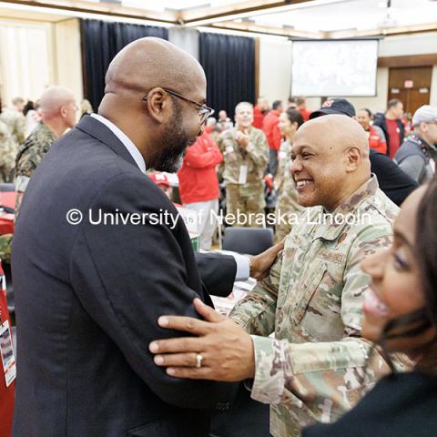 Chancellor Rodney Bennett, left, shakes hands with General Anthony J. Cotton during the Huddle Up Pre-Game Celebration inside the Nebraska Union Ballroom. Chancellor’s tailgate party. November 2, 2024. Photo by Jordan Opp / University Communication and Marketing.