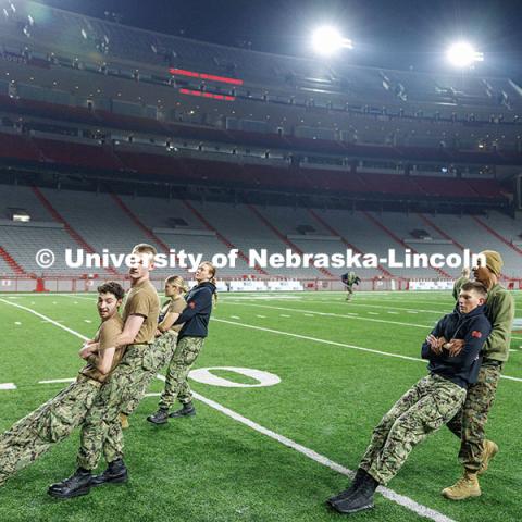 NROTC midshipmen preform buddy drags on the field. Navy and Marine Corps 249th birthday celebration physical training in Memorial Stadium. November 8, 2024. Photo by Jordan Opp / University Communication and Marketing.