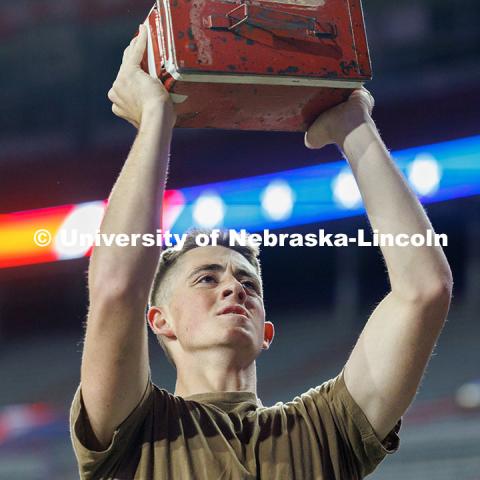 Midshipman Cedric Knudsen lifts an ammo crate into the air. Navy and Marine Corps 249th birthday celebration physical training in Memorial Stadium. November 8, 2024. Photo by Jordan Opp / University Communication and Marketing.