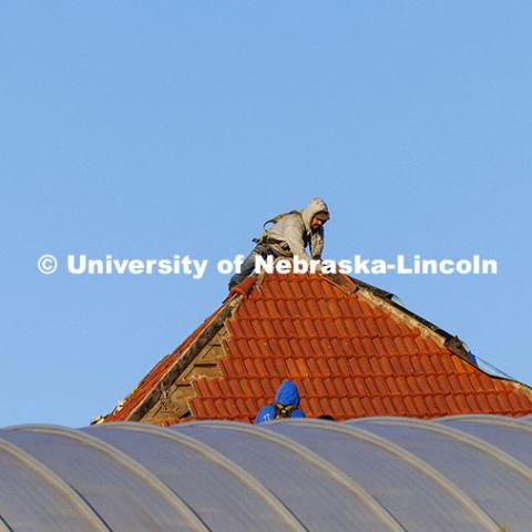 Workers remove the roofing tiles on the Temple Building. November 12, 2024. Photo by Craig Chandler / University Communication.