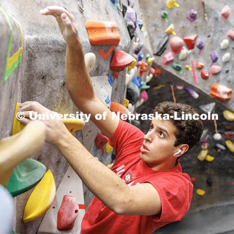 Vitor Lombardi Labegaline, junior, reaches the top of the rock wall in the Campus Recreation facility on City Campus. The League of Extraordinary Boulderers program is designed to teach participants climbing techniques and build friendships with others interested in bouldering. November 20, 2024. Photo by Jordan Opp / University Communication and Marketing.