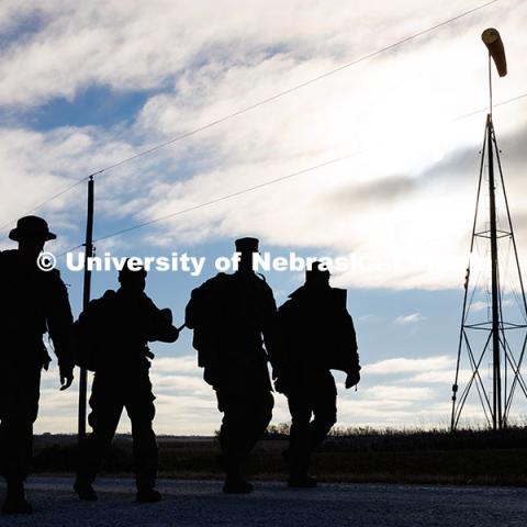 Army ROTC cadets Joe Wiese (from left) Malorie Mulligan, and Max Holmstrom, walk alongside Nebraska National Guard member Cory Zelfel as they walk from Wabash to Alvo. Ruck March. November 21, 2024. Photo by Jordan Opp / University Communication and Marketing.