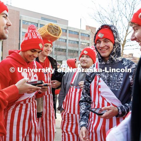 Smith Hall residents wearing red and white striped oversalls wait at the front of the line to enter Memorial Stadium. Nebraska vs. Wisconsin football game. November 23, 2024. Photo by Jordan Opp / University Communication and Marketing.