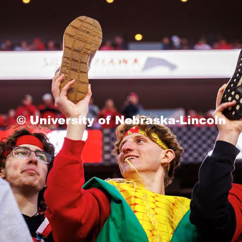 Students hold their shoes up at kick-off at the Huskers vs. Wisconsin football game. November 23, 2024. Photo by Kristen Labadie / University Communication.