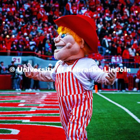 Herbie wearing red and white striped overalls works the crowd during the 4th quarter celebration at the Huskers vs. Wisconsin football game. November 23, 2024. Photo by Kristen Labadie / University Communication.